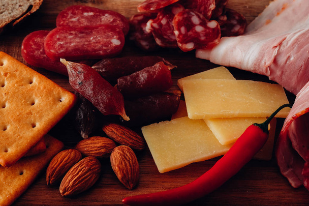 Cold smoked meat plate with prosciutto, salami, bacon, cheese on wooden background, loseup. - Foto, Imagen