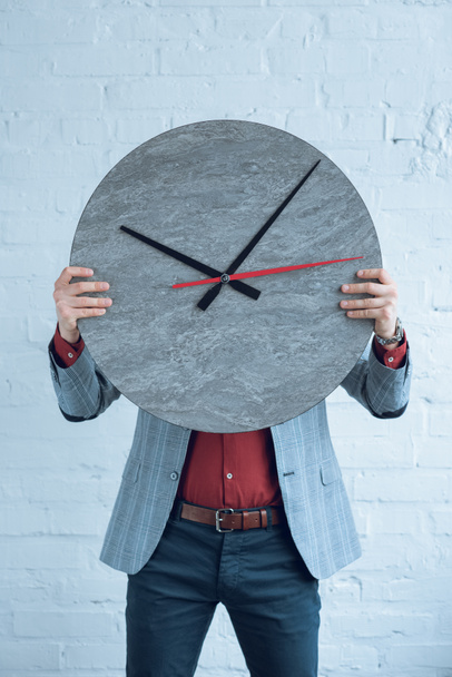 Man holding large clock in front of his face - Foto, imagen