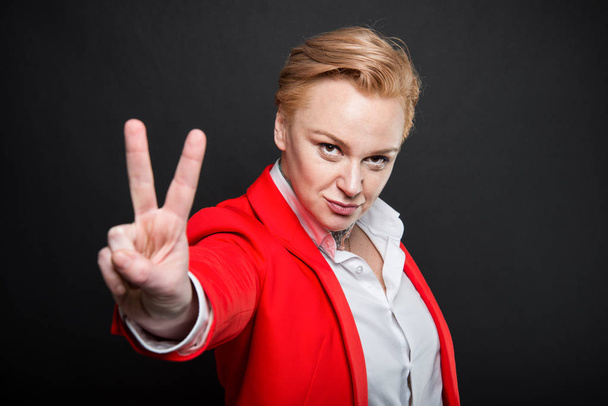 Retrato de atractiva mujer de negocios mostrando gesto de paz
 - Foto, Imagen
