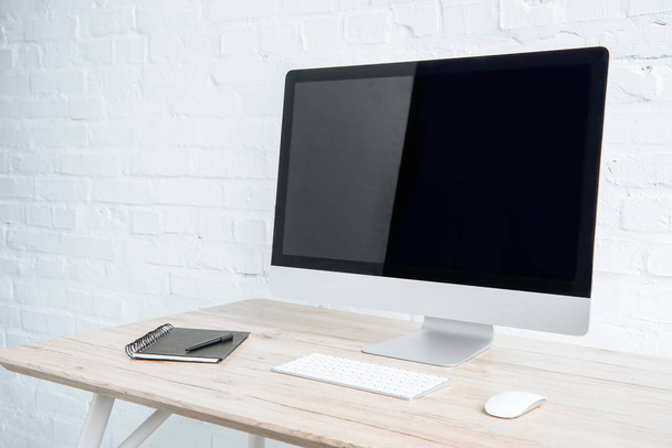 Порожній екран комп'ютера з блокнотом на столі в легкому офісі
  - Фото, зображення