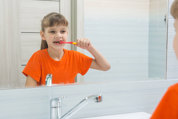 Girl waking up in the morning brushing her teeth in the bathroom - Photo, image