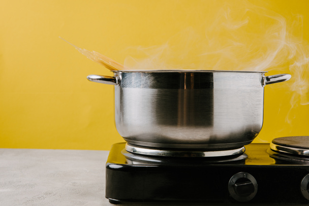közeli lövés a sárga stewpot forró spagetti - Fotó, kép