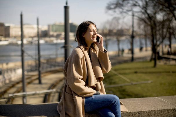 Жінка розмовляє по мобільному телефону в парку
 - Фото, зображення