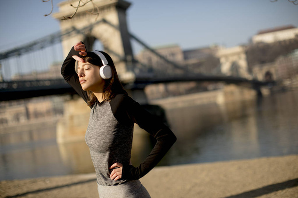 Молода жінка-спортсменка робить перерву від тренувань на відкритому повітрі
 - Фото, зображення