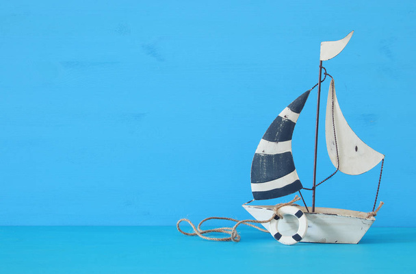 concetto nautico con barca a vela decorativa bianca su tavolo di legno blu
. - Foto, immagini