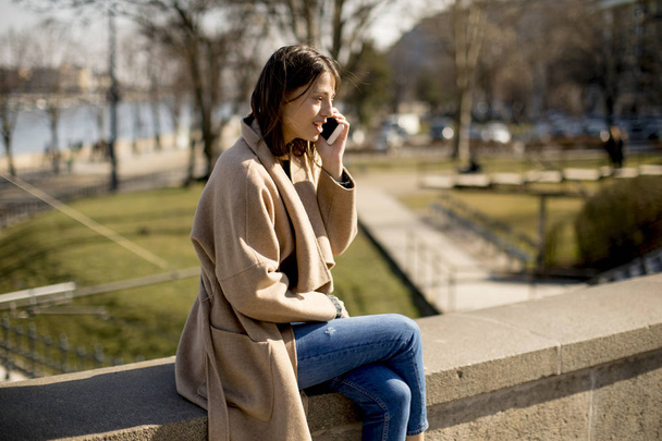 žena mluvila na mobilním telefonu v parku - Fotografie, Obrázek