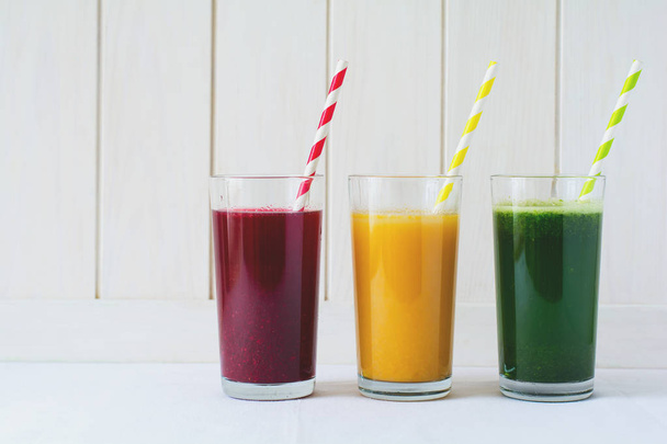 Detox drinks in glass: fresh smoothies from vegetables: beet, pumpkin and spinach on white background - Fotó, kép