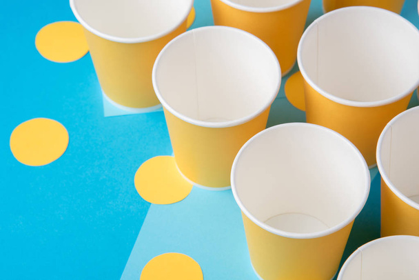 Bicchieri di carta gialla per una festa su sfondo blu
 - Foto, immagini