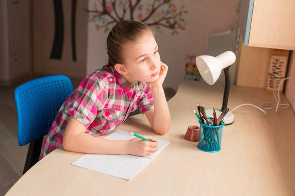 Cute little girl writing her homework - Fotoğraf, Görsel