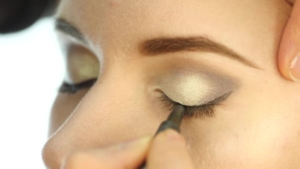 Professional makeup artist applying eye makeup, shadows and eyeliner. slow motion - Filmati, video