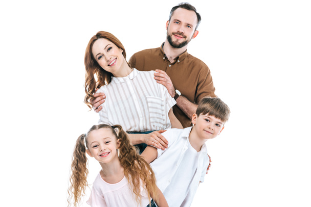 cheerful family with two children standing together and smiling at camera isolated on white - Фото, зображення