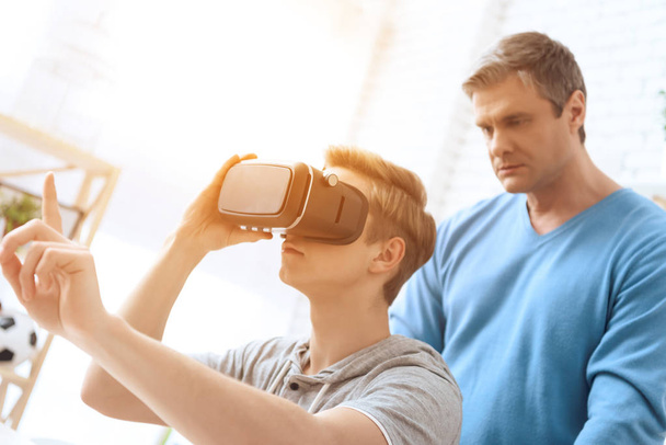 Father disapproving looking on son playing on virtual reality - Foto, immagini