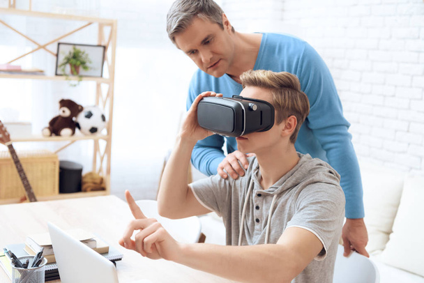 Father disapproving looking on son playing on virtual reality - Foto, immagini