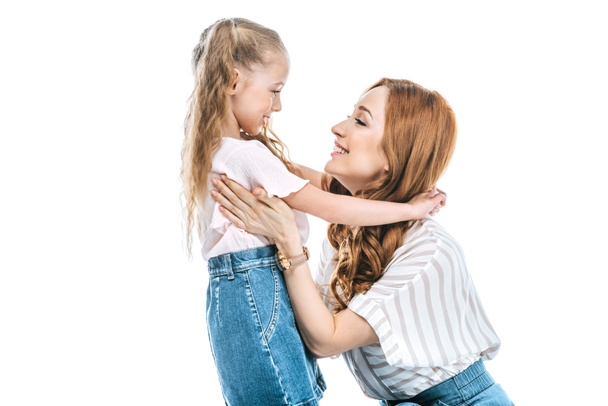 side view of beautiful happy mother and daughter hugging and smiling each other isolated on white - Valokuva, kuva