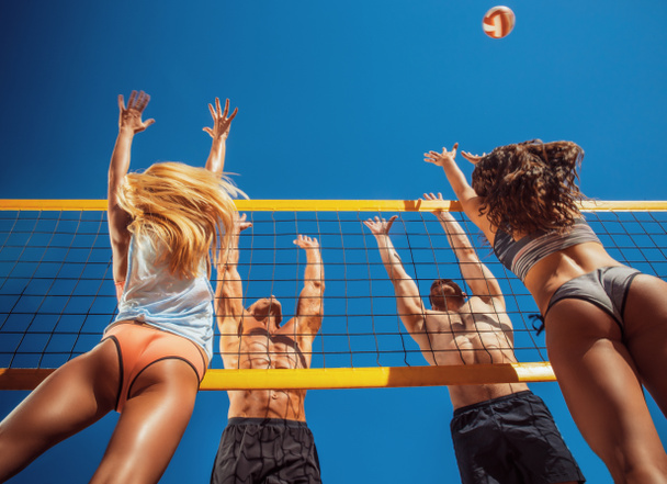 Skupiny přátel hrát volejbal na pláži. - Fotografie, Obrázek