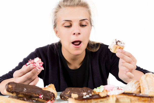 Young woman eating cupcakes with pleasure after a diet - Foto, afbeelding