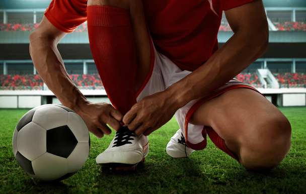 Soccer player tying shoes - Foto, Imagem