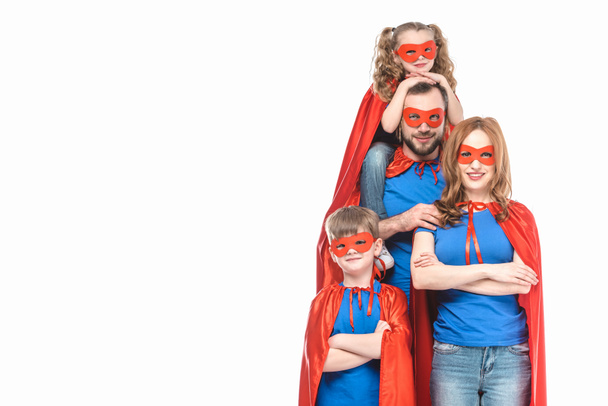 happy super family in masks and cloaks smiling at camera isolated on white  - Photo, Image