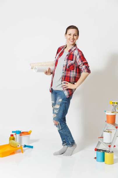 Full length of pretty woman in casual clothes standing near instruments for renovation apartment home isolated on white background. Wallpaper, accessories for gluing, painting tools. Repair concept. - Photo, Image