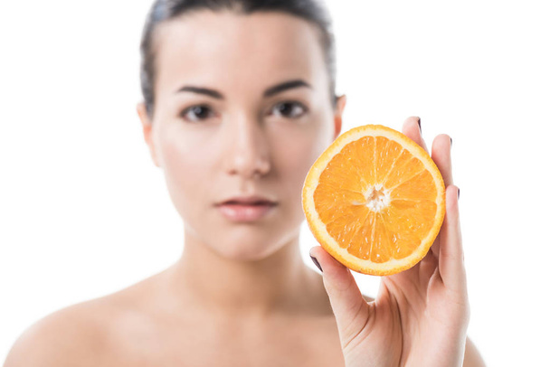 attractive naked girl with clean skin holding half of orange isolated on white - Фото, зображення