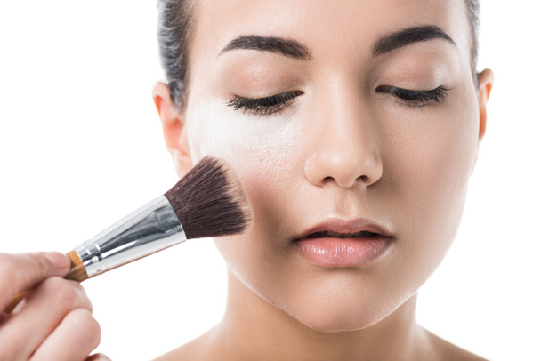 abgeschnittenes Bild einer Visagistin beim Make-up für junge Frau mit Gesichtspuder isoliert auf Weiß - Foto, Bild