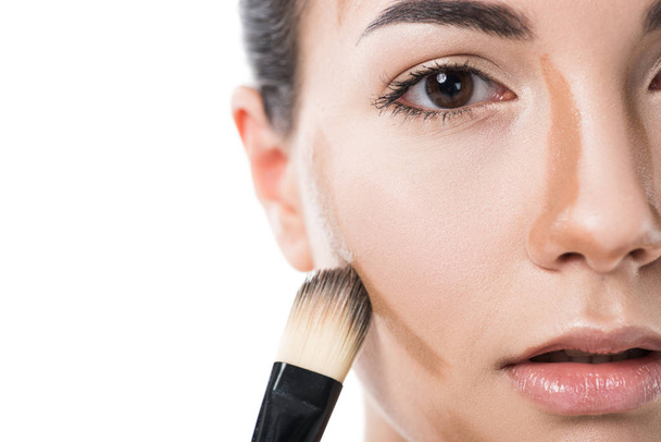 cropped image of beautiful girl applying foundation cream with brush isolated on white - Fotografie, Obrázek