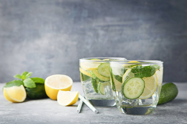 Lemonade with cucumbers, lemons and mint leaves in glasses on wooden table - Фото, зображення