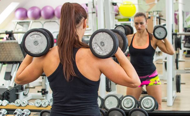 Woman with dumbbells. - 写真・画像