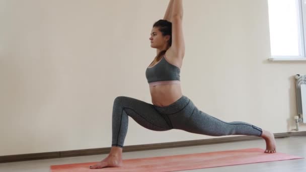fitness female beim Stretching-Workout auf der Trainingsmatte. junge Frau trainiert auf Fitnessmatte in der Halle - Filmmaterial, Video