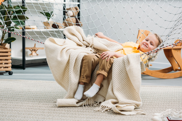 Smiling little boy laying in rope hammock  - Foto, Bild