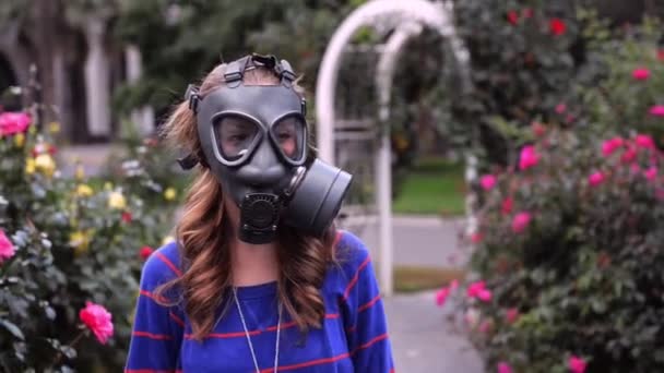 dívka v plynové masky voní květiny - Záběry, video
