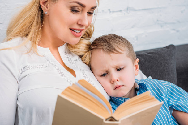 Mother reading book to upset little son  - Photo, image