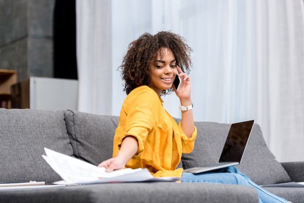 glückliche junge Frau arbeitet und telefoniert zu Hause auf der Couch - Foto, Bild