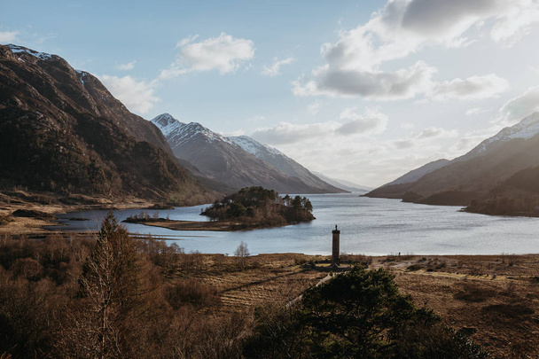 View of the Glenfinnan Monument, Loch Shiel and Scottish landscape near Glenfinnan, Inverness-shire, Scotland, on a cold spring sunny day. - Foto, afbeelding