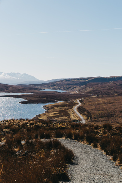 背景上の湖 Leathan とオールドマン オブ ストー トレッキング、スカイ島、スコットランド、雪を頂いた山から道路表示. - 写真・画像
