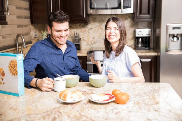 Porträt einer schönen jungen Frau beim Frühstück mit ihrem Freund in der heimischen Küche - Foto, Bild