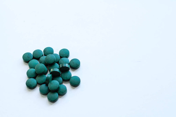 Green pills background. Close up green pills. Spirulina, dietary supplement - Фото, изображение