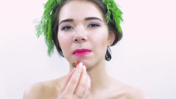 Chica joven con perejil verde en la cabeza, comer cola de fresas. Pose en la cámara
 - Imágenes, Vídeo