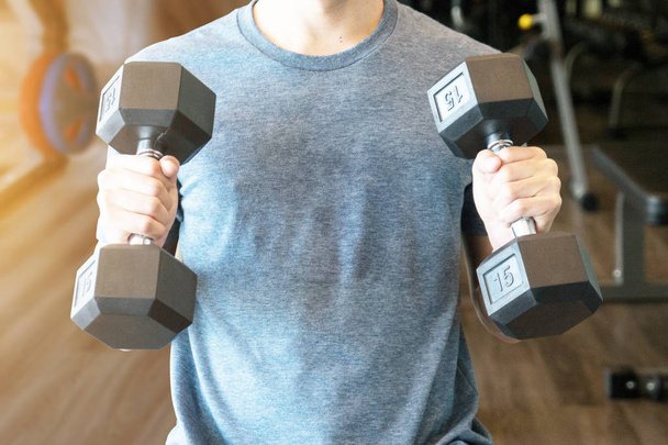 A man workout beginner  with dumbbell for muscles at gym - Foto, afbeelding