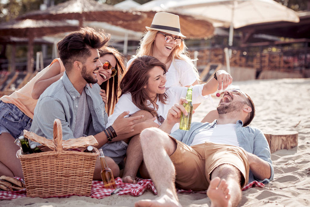 Amigos bebiendo cervezas y divirtiéndose en fiesta en la playa
 - Foto, imagen