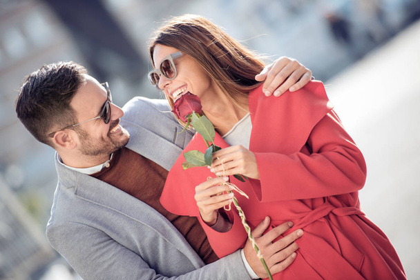 Young man gifting red rose to girlfriend - Фото, зображення