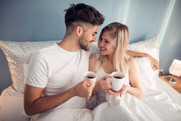 Genç çift yatakta sabah kahve içme - Fotoğraf, Görsel
