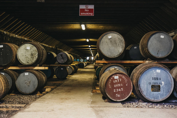 BRORA, SCOTLAND - 22 MARZO 2018: Barili di whisky all'interno del magazzino Brora Distillery in Scozia, raro whisky Brora davanti. La distilleria è attualmente in fase di ristrutturazione per la riapertura nel 2020
. - Foto, immagini
