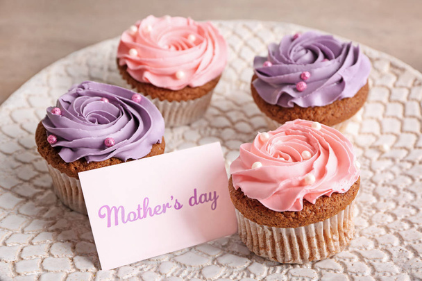 Sabrosos cupcakes con tarjeta para el día de la madre en el plato
 - Foto, Imagen