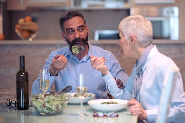 Зрелая пара обедает вместе дома
 - Фото, изображение