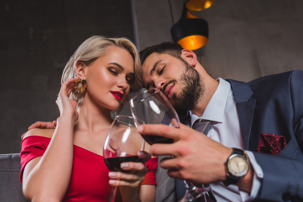 sensual stylish young couple drinking red wine together - 写真・画像