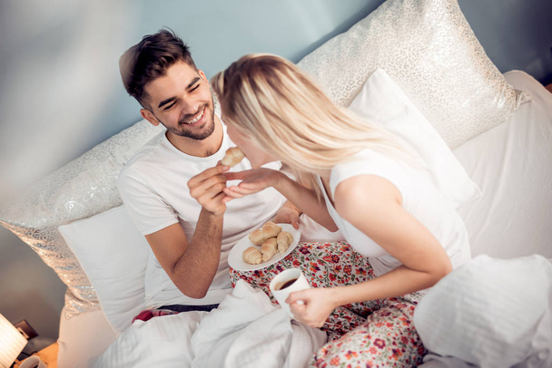 Young couple drinking coffee in bed at morning - Foto, afbeelding