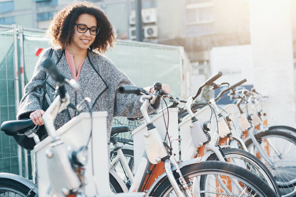 Afroamerikanerin nimmt Fahrrad in einer Fahrradverleihplattform - Foto, Bild