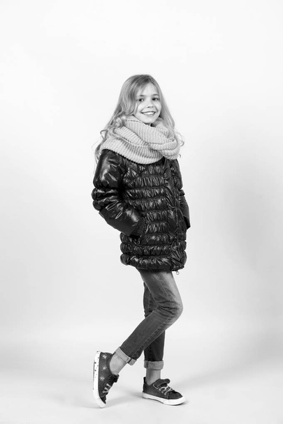Kid with long blond hair black coat, scarf, jeans, sneakers - Photo, Image