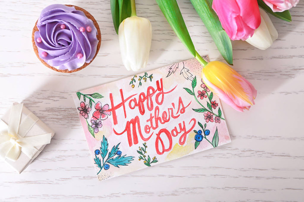 Bela composição com cartão artesanal para o Dia das Mães na mesa de madeira branca
 - Foto, Imagem